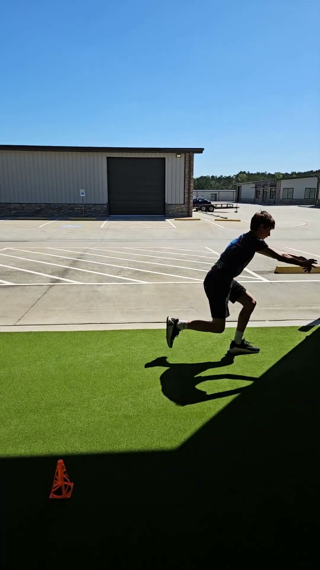 Athlete loading a rotational medicine ball throw outside the Activ8 facility
